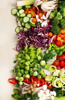 Çeşitli taze sebzeler: havuç, salatalık, kırmızı dolma biber, domates, salata, hafif arkaplanda soğan. Üst Manzara. Boşluğu kopyala.