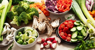 Tabakta ve kâselerde taze kesilmiş sebzeler. Vejetaryen, hafif arka planda vejetaryen yemeği. Üst görünüm.