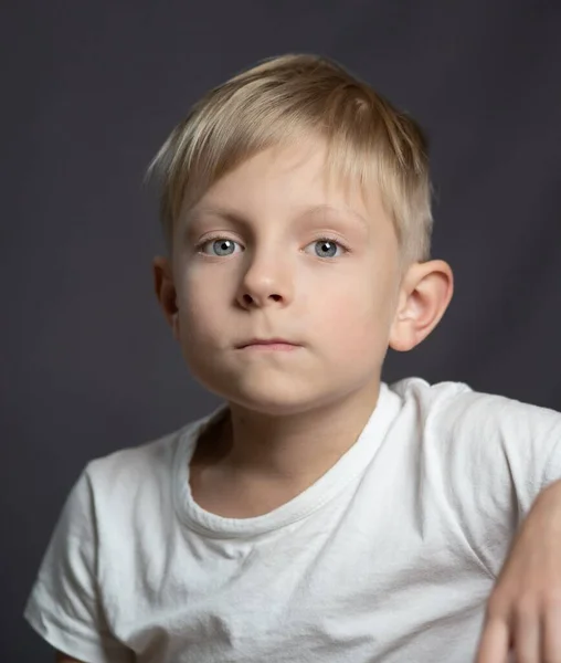 一个蓝眼睛金发 悲伤的高加索男孩看着摄像机的工作室肖像 — 图库照片