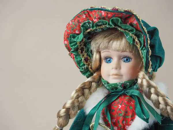 ヴィンテージ磁器人形女の子ブロンドとともに青い目で緑のドレスで赤いトリムと帽子 — ストック写真