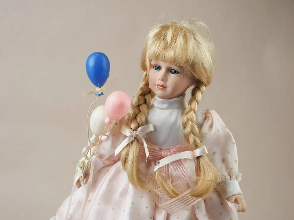 古色古香的瓷娃娃 金发碧眼的金发姑娘 身穿浅色连衣裙 头戴白色 粉色和蓝色气球 — 图库照片