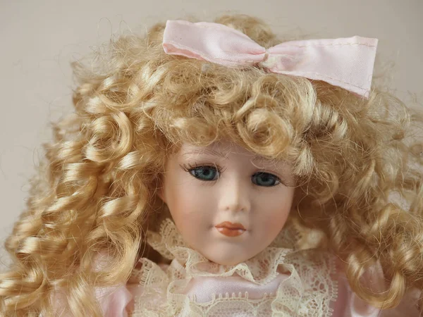 古色古香的瓷娃娃女孩 蓝眼睛 一头卷曲的金发 头戴蝴蝶结 身穿浅色连衣裙 — 图库照片