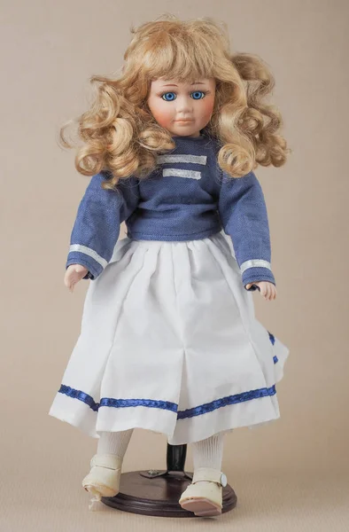 ヴィンテージ磁器人形青い目のブロンドとヴィンテージ磁器人形の女の子とともに緩い巻き裸の髪で青いブラウスに2つの白い水平ストライプ — ストック写真