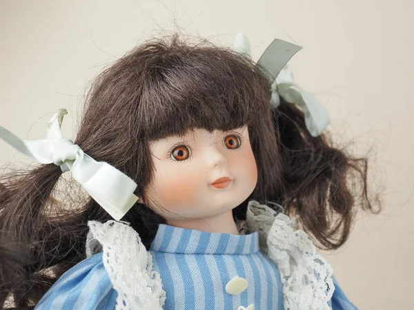古色古香的瓷娃娃女孩 褐色眼睛 带辫子的缎带 蓝色连衣裙 白色垂直条纹和花边围裙 — 图库照片