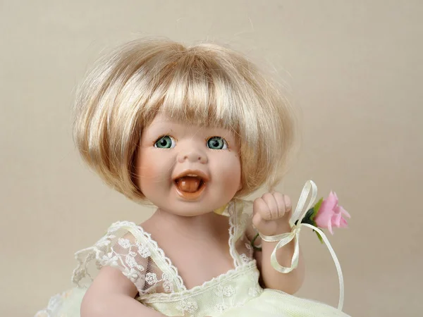 ヴィンテージ磁器人形赤ちゃん女の子とともに緑目と口 ブロンドとともにAローズ縛らへ彼女の左手 — ストック写真