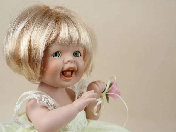 古瓷娃娃女婴 绿眼张嘴 金发碧眼 左手绑着玫瑰 — 图库照片