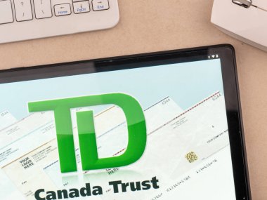In this photo illustration, TD Canada Trust logo seen displayed on a tablet.