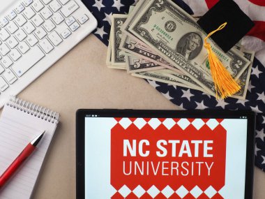 In this photo illustration, North Carolina State University  logo seen displayed on a tablet.