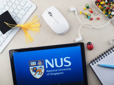 Bu resimde, Singapur Ulusal Üniversitesi (NUS) logosu bir tablette sergilenmektedir..