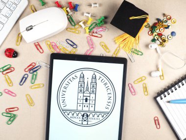 Bu resimde, Zürih Üniversitesi logosu bir tablette sergilenmektedir..