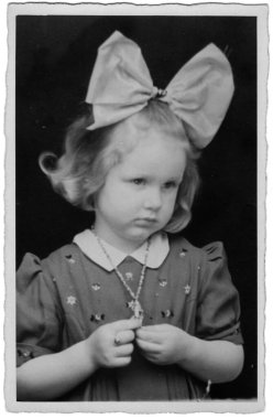 Kafasında parlak bir fiyonk olan beyaz bir kızın stüdyo portresi. Almanya, 22 Nisan 1935.