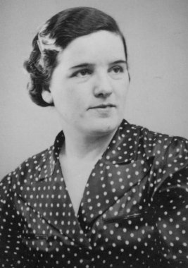 Antik fotoğraf, saçını süsleyen bir çiçekle benekli elbise giyen bir kadının stüdyo portresini gösteriyor. Almanya. Tarih bilinmiyor, yaklaşık 1930 'larda.