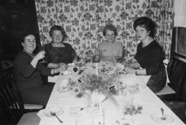 Antik bir fotoğrafta bir parti sırasında dört kadın yemek masasında otururken görülüyor. Almanya. Tarih bilinmiyor, 1950 'lerden kalma.