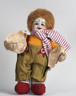 Elinde gazeteler olan klasik Alman bebek kızıl saçlı beyaz palyaço. Porselen bebekler 18. yüzyılda Fransa 'da ortaya çıktı..