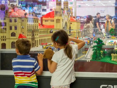 Prag, Çek Cumhuriyeti - 10 Mayıs 2024: Çocuklar yeni istasyonun ana salonundaki Prag Merkez Tren İstasyonu 'nun eski bir modeline bakıyorlar