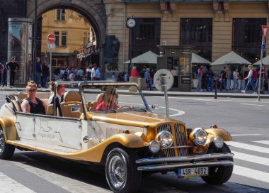 Prag, Çek Cumhuriyeti - 10 Mayıs 2024: Turistler, Pudra Kulesi 'nin önündeki meydan boyunca eski bir stil olarak açık bir spor arabaya biniyorlar
