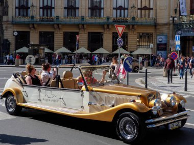Prag, Çek Cumhuriyeti - 10 Mayıs 2024: Turistler, Pudra Kulesi 'nin önündeki meydan boyunca eski bir stil olarak açık bir spor arabaya biniyorlar