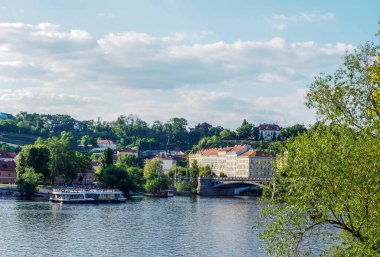 Prag, Çek Cumhuriyeti - 10 Mayıs 2024: Charles Köprüsü manzaralı bir eğlence gemisi Vltava Nehri boyunca yol alıyor