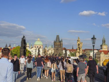 Prag, Çek Cumhuriyeti - 10 Mayıs 2024: Charles Köprüsü 'nde güneşli bir günde turistler yürüyor.