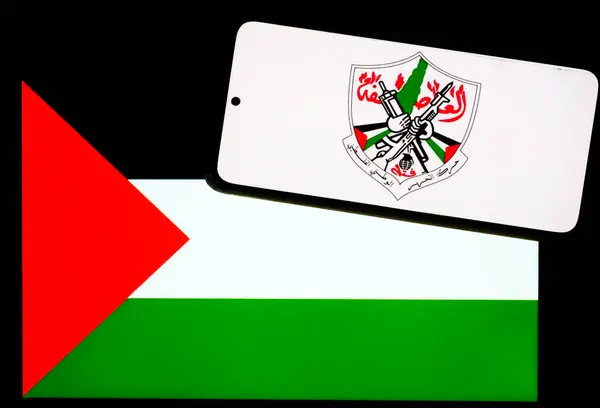 stock image Ukraine - June 19, 2024: In this photo illustration, Fatah (Palestinian National Liberation Movement)  logo seen displayed on a smartphone and Palestine flag on  tablet screen. 