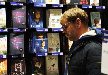 Almanya, Passau - 5 Aralık 2024: Bir adam Bayan Merkel 'in kitabını bir kitapçıda okuyor. Eski Alman şansölyenin 