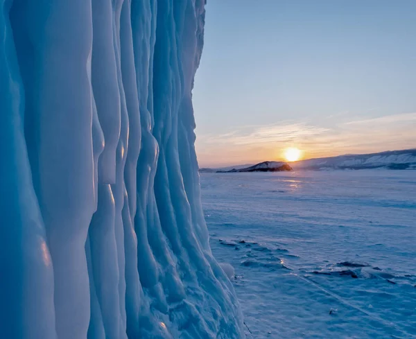凍えるような冬の夕日にバイカル湖の岩からつららが吊るされる — ストック写真