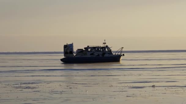 日没時にバイカル湖の凍結氷の表面にホバークラフト Khivus 氷の上の輸送 — ストック動画