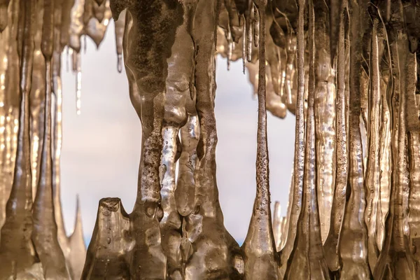 冬にバイカル湖の氷の洞窟 日没の太陽の下で洞窟の中の青い氷とつらら オルホン島 バイカル シベリア ロシア — ストック写真
