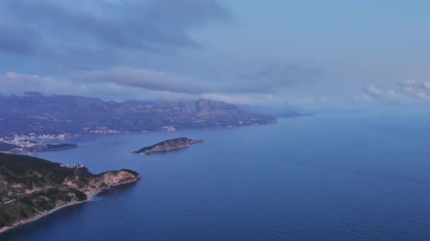 モンテネグロの山々やブドヴァ市とアドリア海の海岸と夕暮れの雲の空中ビュー 旅行の風景の背景と自然景観 — ストック動画