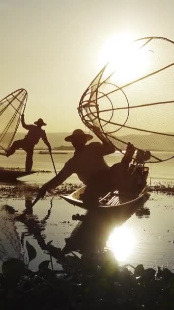ミャンマー旅行の魅力のランドマーク ミャンマーのインレー湖で漁網を持つ伝統的なビルマの漁師は 独特の1本足の漕ぎスタイルで有名です 垂直ビデオ — ストック動画