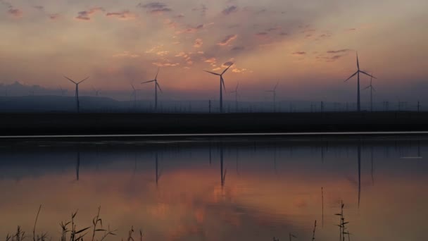 Rüzgâr Değirmenleri Güneş Doğmadan Önce Göl Kenarında Rüzgar Enerjisi Türbinleri — Stok video