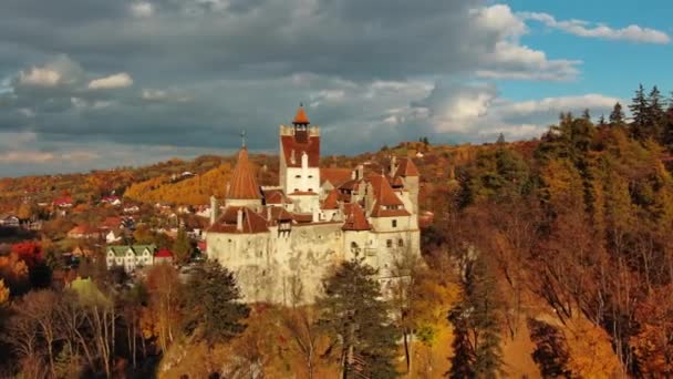 ルーマニアのトランシルヴァニア地方のブラン城の眺めの周りの空中 秋の季節と暗い雲 — ストック動画