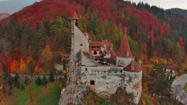 ルーマニアのトランシルヴァニア地方のブラン城の眺めの周りの空中 秋の季節と暗い雲 — ストック動画
