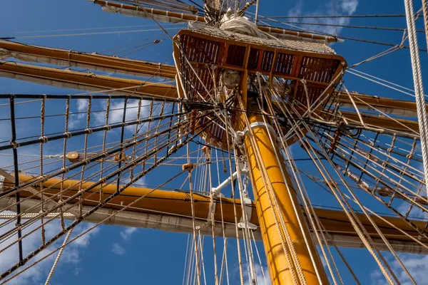 帆船木桅杆的低角度视图及蓝天云下的帆索 — 图库照片