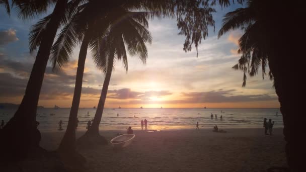海の近くに人々や手のひらが広がった トロピカルホワイトビーチ ボラカイ島 フィリピン スローモーション4Kでの夕日 — ストック動画