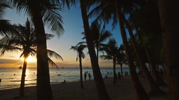 海の近くに人々や手のひらが広がった トロピカルホワイトビーチ ボラカイ島 フィリピン 4Kでの夕日 — ストック動画