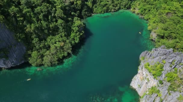 フィリピンの熱帯島の空中観測 青いラグーンと湖 白い砂浜 岩の崖の山とサンゴ礁のボート — ストック動画