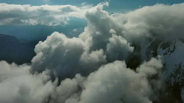 Létání Přes Krásné Bílé Nadýchané Mraky Mezi Vysokými Skalnatými Horami — Stock fotografie