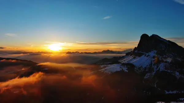 Aerial view of amazing rocky mountains in snow and sunrise sun, Dolomites, Italy