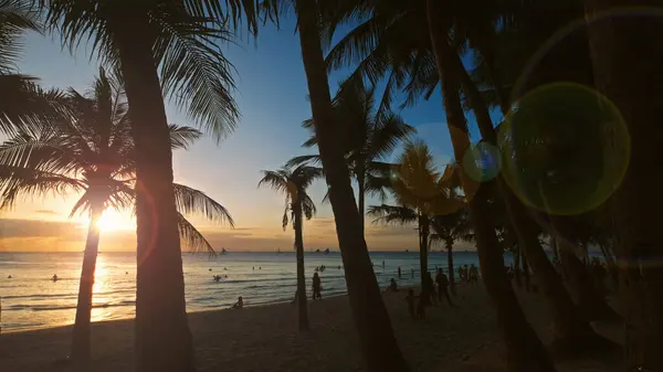 海の近くに人々や手のひらが広がった トロピカルホワイトビーチ ボラカイ島 フィリピンでの夕日 ロイヤリティフリーのストック画像