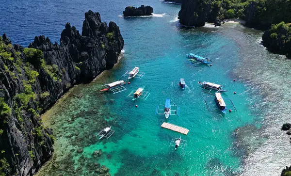 フィリピンの熱帯島の空中観測 青いラグーンと湖 白い砂浜 岩の崖の山とサンゴ礁のボート ロイヤリティフリーのストック画像