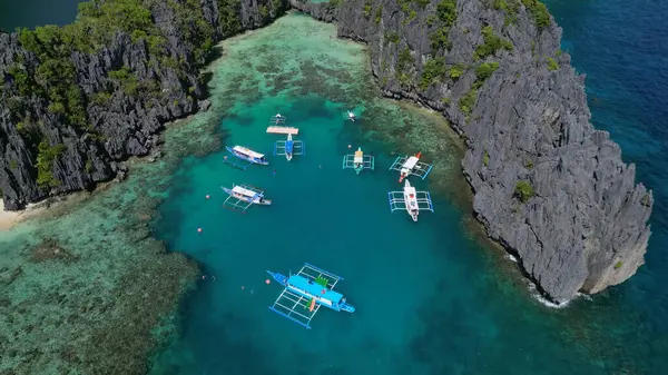 菲律宾热带岛屿的空中景观 蓝色泻湖和湖泊 白色沙滩 岩石悬崖和珊瑚礁中的船只 免版税图库照片