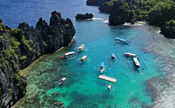フィリピンの熱帯島の空中観測 青いラグーンと湖 白い砂浜 岩の崖の山とサンゴ礁のボート ストック写真