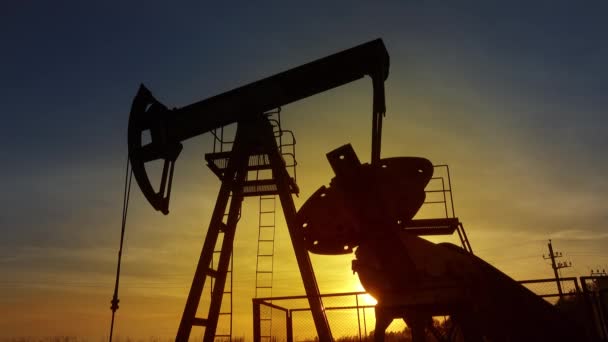 Рабочий Силуэт Масляного Насоса Против Заката Нефтяная Промышленность — стоковое видео