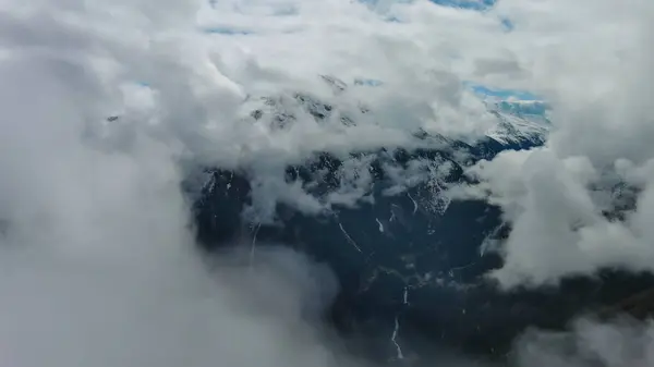Terbang Diantara Awan Pemandangan Udara Dari Pegunungan Yang Tertutup Salju Stok Gambar Bebas Royalti