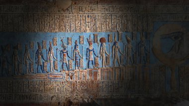 Light spot on hieroglyphic carvings and paintings on the interior walls of an ancient egyptian temple clipart