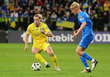 Wroclaw, Polonya - 26 Mart 2024: Ukraynalı Mykhailo Mudryk (L) Wroclaw 'daki Tarczynski Arena' da oynanan UEFA 2024 play-off maçı sırasında İzlandalı Hakon Arnar Haraldsson ile top için mücadele ediyor.