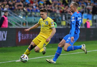 Wroclaw, Polonya - 26 Mart 2024: Ukraynalı Viktor Tsygankov (L), Wroclaw 'daki Tarczynski Arena' da oynanan UEFA EURO 2024 play-off maçı sırasında Gudmundur Thirarinsson ile top için mücadele ediyor.