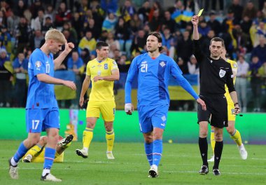 Wroclaw, Polonya - 26 Mart 2024: Hakem Clement Turpin (FRA), Tarczynski Arena 'da oynanan UEFA 2024 play-off maçı sırasında İzlandalı Arnar Haraldsson' a sarı kart gösterdi.