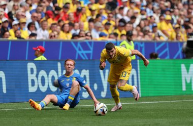 Münih, Almanya - 17 Haziran 2024: Ukraynalı Yukhym Konoplia (L), Münih 'teki Münih Futbol Arena' da oynanan UEFA 2024 grup maçında Rumen Valentin Mihaila ile top için mücadele ediyor.